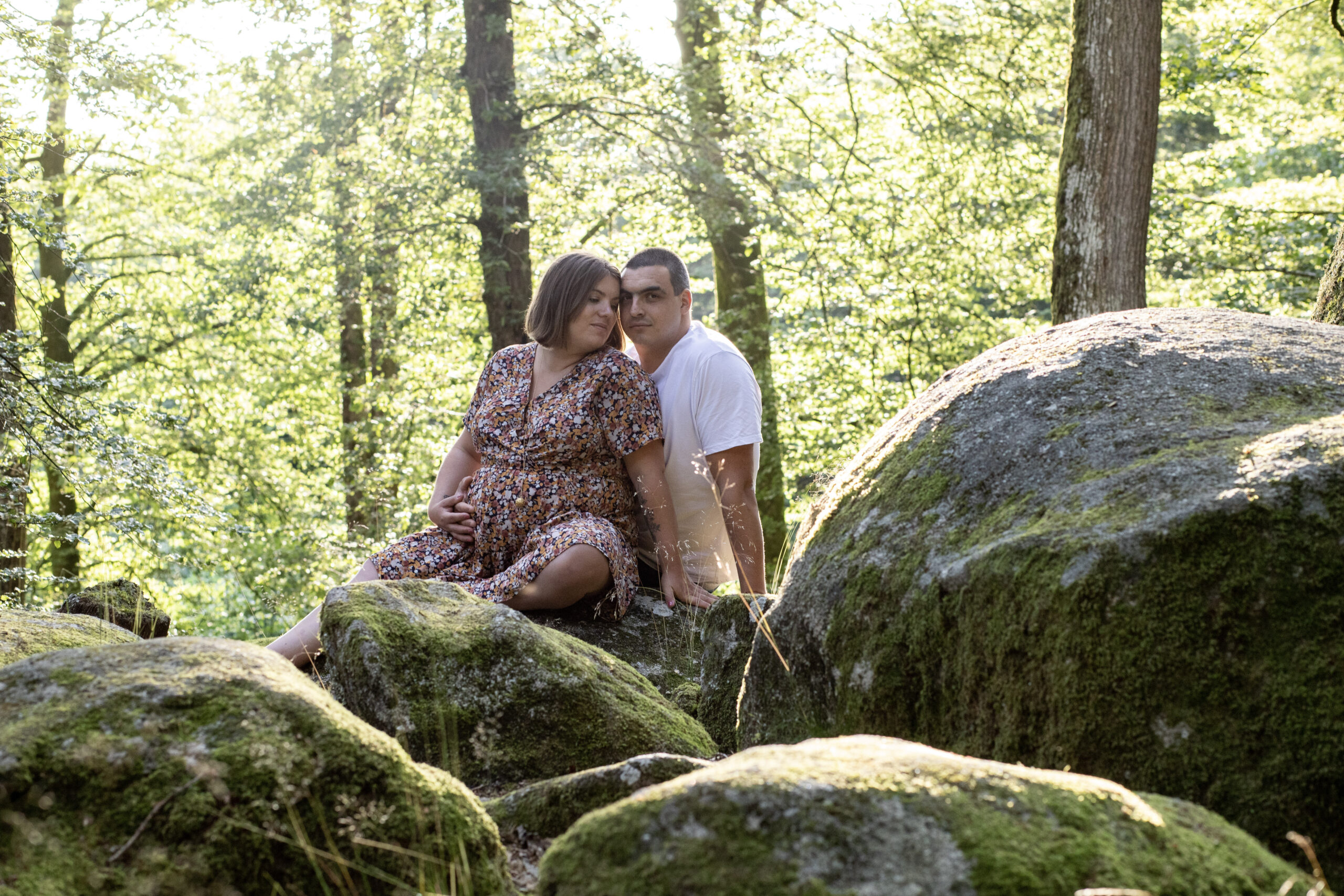Couple assis sur de gros rochers couverts de mousse en forêt